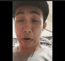 a man wearing a hat and headphones is making a funny face while looking at the camera .