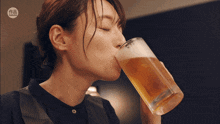 a woman drinking a glass of beer with a watermark that says ' taiwan ' on it