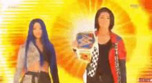 two women are standing next to each other in front of a yellow background holding a wrestling championship belt .