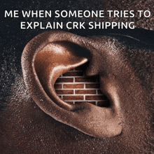 a close up of a man 's ear with a brick wall behind it