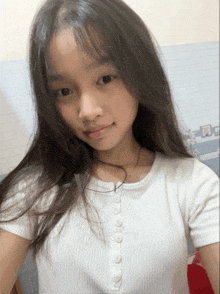 a girl with long hair is wearing a white shirt with buttons on the front