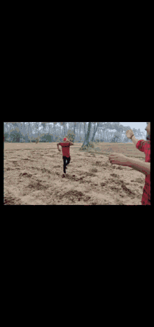 a man wearing a red hat and a red shirt is kneeling down in a field .