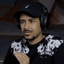 a man wearing headphones and a hat with the word awa on the bottom right