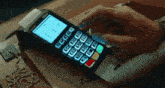 a person is using a credit card machine with the numbers 0-9 on it