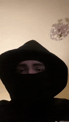 a person wearing a black hoodie with a hole in it