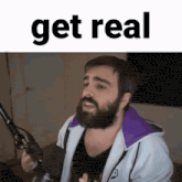 a man with a beard stands in front of a microphone with the word get real above him