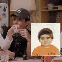 a man wearing a new york yankees hat looks at a picture of a child