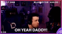 a man wearing headphones is sitting in front of a microphone and says oh yeah daddy !