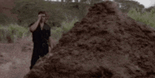 a man standing in front of a pile of dirt with the words that is one big pile of shit