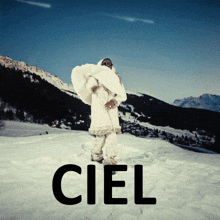 a person in a white coat is standing in the snow with the word ciel above them