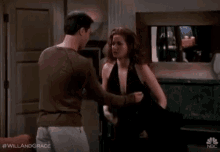 a man is touching a woman 's breast while standing next to her .