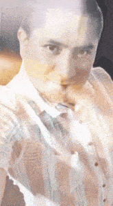 a man in a striped shirt and tie is looking at the camera .