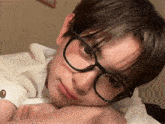 a close up of a person wearing glasses and a white shirt
