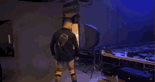 a man in a black shirt with a gold coffin on the back flexes his muscles