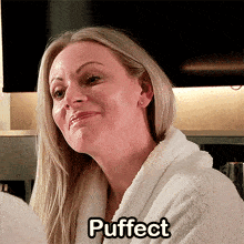 a woman in a bathrobe is smiling with the word puffinct above her