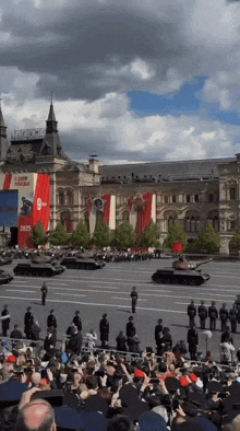 a crowd of people watching a military parade with a sign that says 9 on it