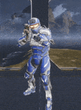 a man in a blue and white armor is holding a rifle