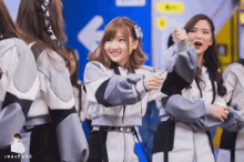a group of girls are standing in front of a blue sign that says n48