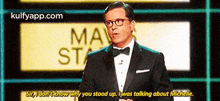a man in a tuxedo and bow tie is talking to someone