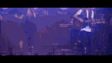a man playing a guitar and a woman singing on a stage with a nord stage in the background
