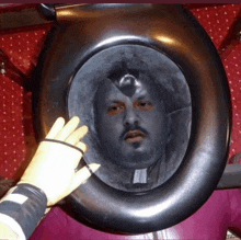 a person is holding a toilet seat with a man 's face on it