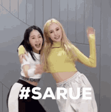 two women are standing next to each other and laughing .