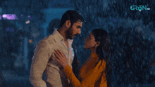 a man and a woman are standing in the rain with green hd written in the corner
