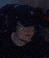 a man wearing a hat and headphones is sitting in a room .