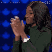 a woman in a green shirt is clapping her hands in front of a microphone ..