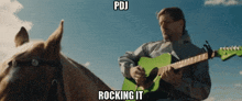 a man playing a green guitar while riding a horse with pdj rocking it below him