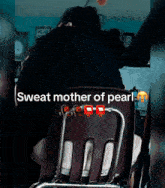 a person sitting in a chair with the words sweat mother of pearl written on the bottom