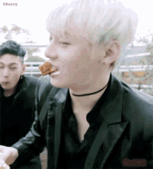 a man with white hair is eating a piece of food and the word cherry is on the bottom right