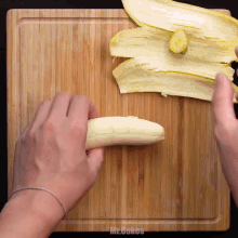a person peeling a banana on a cutting board that says mr.cakes