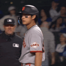 a baseball player for the giants is standing in front of a referee