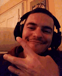 a man wearing headphones is smiling and giving the peace sign