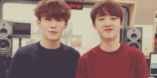two young men are standing next to each other in front of a sign that says ' s.m.p.s. '