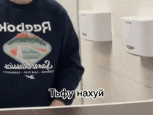 a person wearing a reebok shirt is looking at themselves in a mirror
