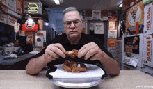 a man is eating chicken wings in a papa johns restaurant