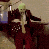 a man in a suit and tie with a green mask on his face .