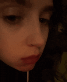 a close up of a woman 's face with a nose ring .