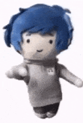 a stuffed doll with blue hair is wearing a gray hoodie and black pants .