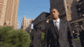 a man in a suit walks down a city street in front of a building that says ' tommy 's burger '