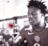 a blurry picture of a man in a red shirt standing in a crowd .