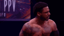 a man with a tattoo on his chest is standing in front of a dark background