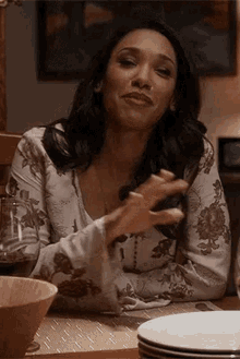 a woman is sitting at a table with plates and bowls .