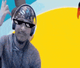a man wearing sunglasses and headphones is giving the ok sign .