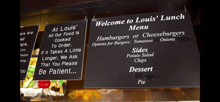 a welcome to louis ' lunch menu hanging from the ceiling