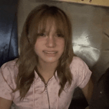 a girl wearing a pink shirt with a zipper that says s on it