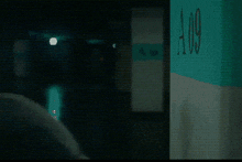 a man is talking on a cell phone in front of a sign that has the letter a on it