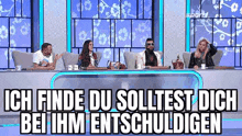 a group of people are sitting at a table in front of a screen with flowers on it .